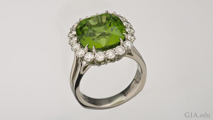 The 10.89 carat peridot in this platinum ring is surrounded by a halo of diamonds, showing off the August birthstone. 