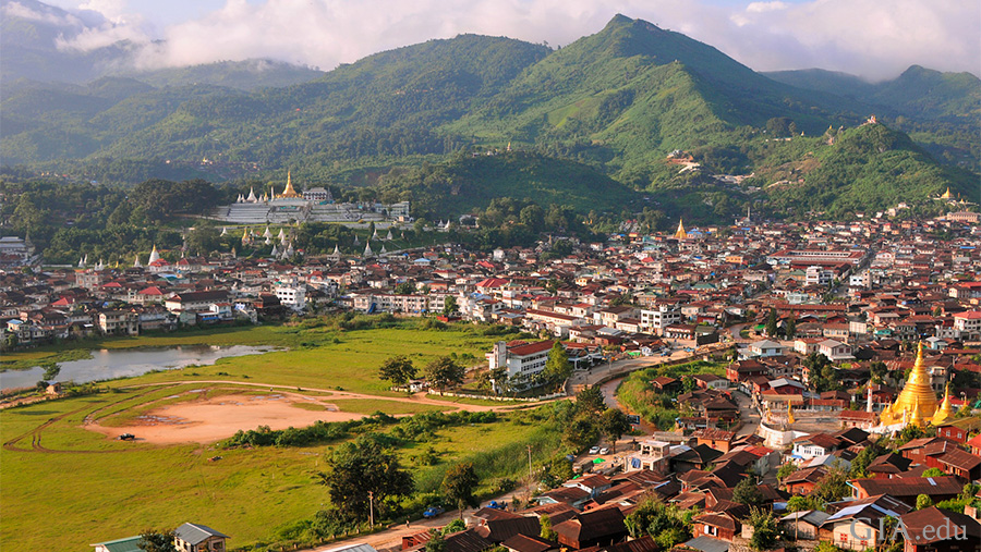 Landscape of a Mogok town where the July birthstone ruby is mined, with a green mountainside and lake created from gem mining in British colonial times.