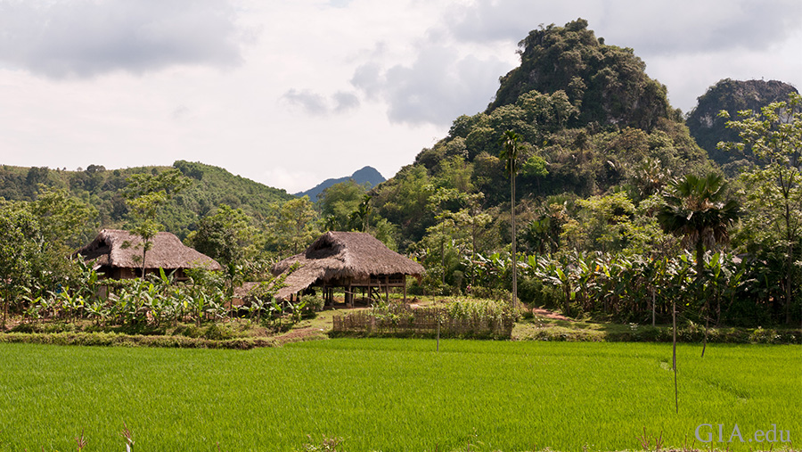 Landscape of a small village surrounded by greenery at the base of the mountains in the Luc Yen region where the July birthstone, ruby is found.