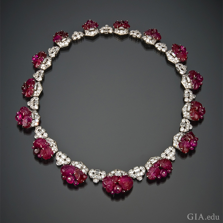 1930’s art deco carved ruby and diamond necklace shows off the July birthstone. Ruby beads are secured to the frame by white metal posts capped with a tiny diamond. 
