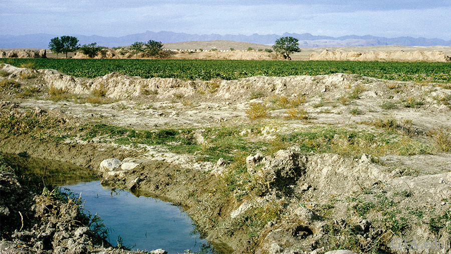 Landscape of a stream running through the terrain with mountains in the distance, near the Nishapur district of Iran where the December birthstone, turquoise, is found.