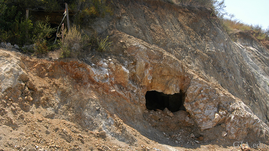 Landscape featuring an old tunnel entrance in a rocky mountain at the Tourmaline King mine where the October birthstone is found.